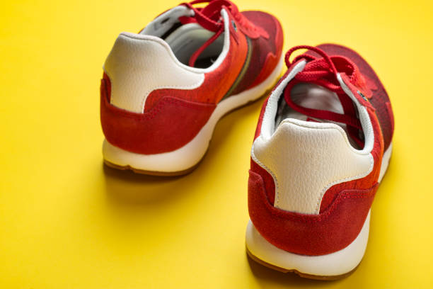 istock New red sneakers on a yellow background. space for text. 1344548476
