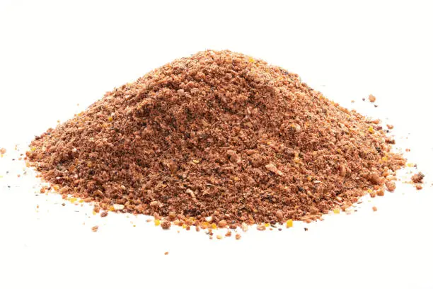 Pile of Nutmeg powder isolated on white background. Used as a spice in many sweet as well as savoury dishes and medicine.