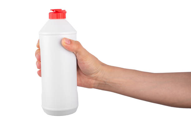 istock Hand holding white bottle with red lid isolated on white background. 1344548583