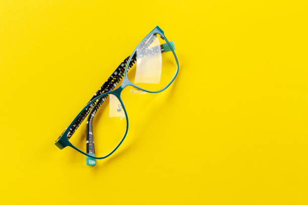 istock Stylish eyeglasses over yellow background. Optical store, glasses selection, eye test, vision examination at optician, fashion accessories concept. 1344549171
