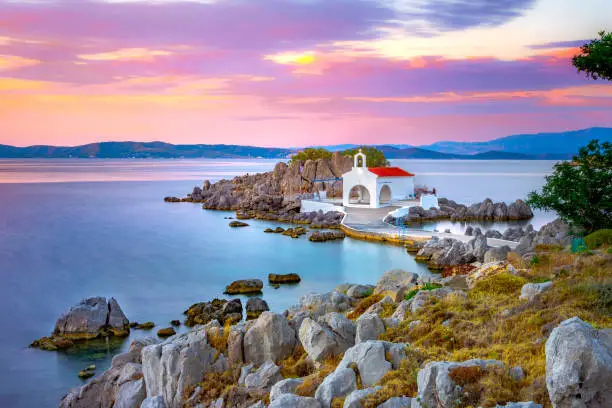 Photo of Little church of Agios Isidoros in the sea over the rocks, Chios island, Greece.