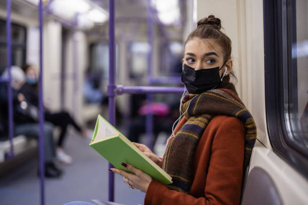istock Young student girl with mask reading a book 1344549623