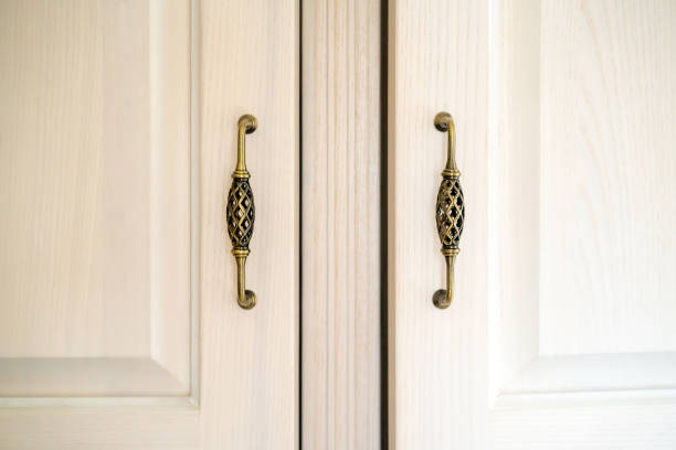 White wood cabinet doors with vintage fittings, retro Provence style door handles, interior details.