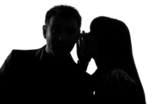 one caucasian couple man and woman  whispering at ear in studio silhouette   on white background