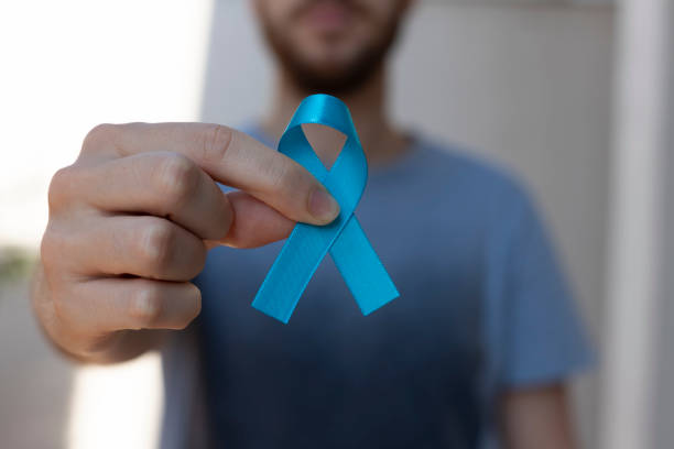 novembro azul. mês de prevenção do câncer de próstata. homem segurando fita azul. saúde dos homens. - novembro azul - fotografias e filmes do acervo