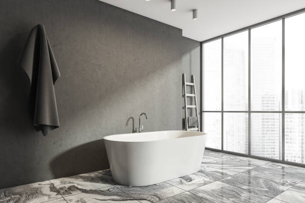 istock Dark bathroom interior with bathtub and empty concrete wall 1344552817