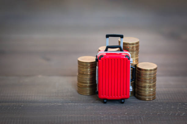 Red Luggage Bag with Stack of coin on wood table