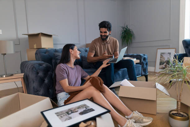 istock Happy couple using laptop after moving into a new home. 1344554333