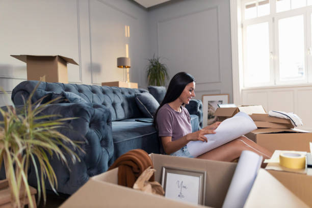 istock Happy woman analyzing house plan after relocating into new home. 1344554485