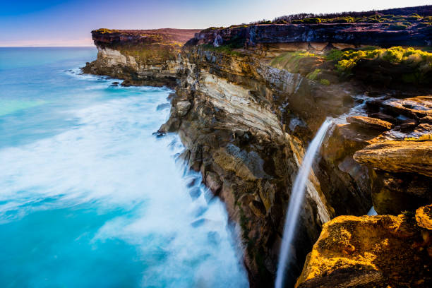 Seascape, coast cliff, and waterfalls in Royal National Park Near the Eaglehead rock in Royal National Park cataract photos stock pictures, royalty-free photos & images