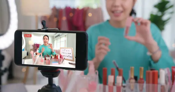 Photo of Asia woman micro influencer record live viral video camera at home studio. Happy fun talk speak advice review hobby in media. Vlogger selfie shoot enjoy work show smile teach like share app.