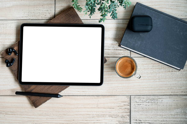 istock Top view blank screen tablet with gadget and coffee cup on wooden background. 1344558866