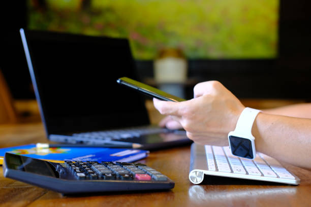 istock Man hand working on laptop computer on table and using smartphone, home quarantine, new normal, technology business concept 1344560696