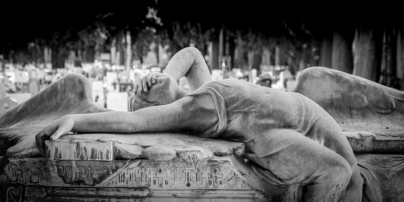 GENOA, ITALY - June 2020: antique statue of angel (1910, marble) in a Christian Catholic cemetery - Italy