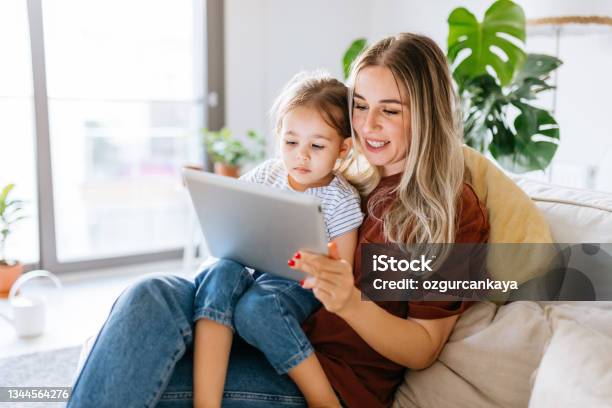 Mother And Daughter Using A Digital Tablet Together Stock Photo - Download Image Now