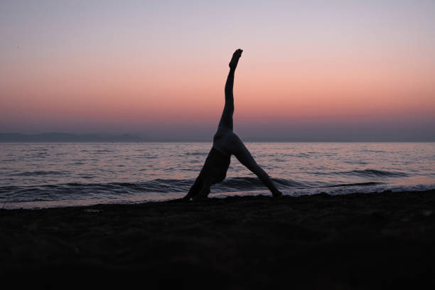 istock Woman practicing yoga on the beach 1344565787