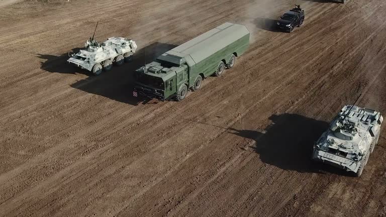 Aerial View -  rocket launcher moves under the cover of heavy equipment