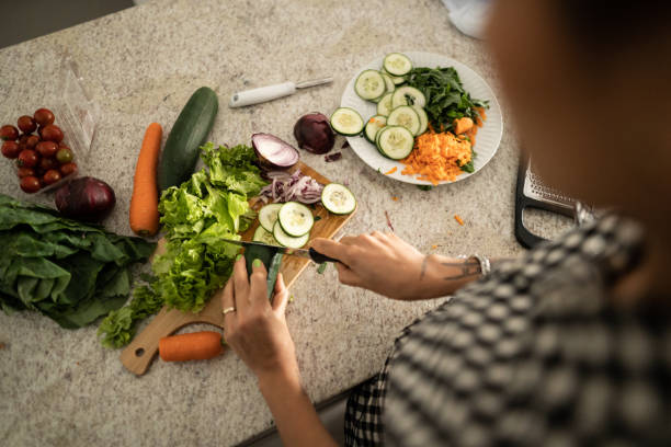 istock Woman cutting vegetables at home 1344566598
