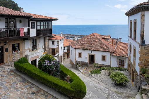 narrow streets of the historic district of Lastres, Asturias, Spain, with its typical steep cobbled streets and the port and sea in the background, fishing village by the sea