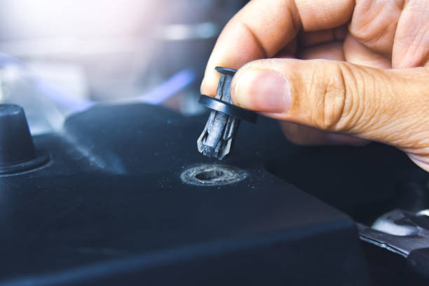 Mechanic hand installing automotive plastic fasteners Mechanic hand installing automotive plastic fasteners to the car body in the auto repair garage rivet stock pictures, royalty-free photos & images