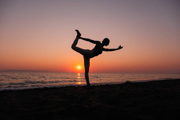 istock Woman practicing yoga on the beach 1344566767