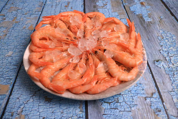 Two Cooked shrimp with full shell isolated on white background and parsley.