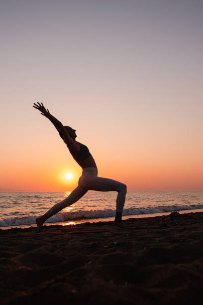 Woman practicing yoga on the beach Woman practicing yoga on the beach yoga stock pictures, royalty-free photos & images