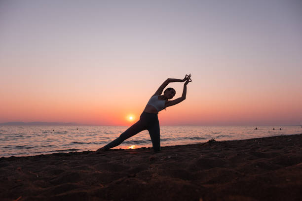 istock Woman practicing yoga on the beach 1344567627