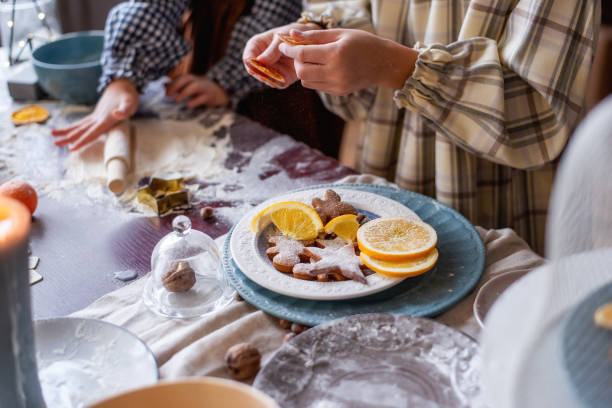 dos niños están horneando galletas de jengibre en la mesa de navidad. comida de año nuevo - christmas child cookie table fotografías e imágenes de stock