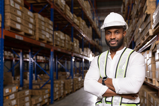 Portrait of logistic warehouse black male staff in safety suite