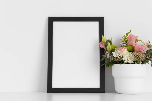istock Black frame mockup with a bouquet of roses on the white table. 1344567850