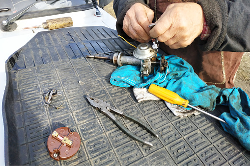 Asian male mechanic repairing motorcycle in workshop