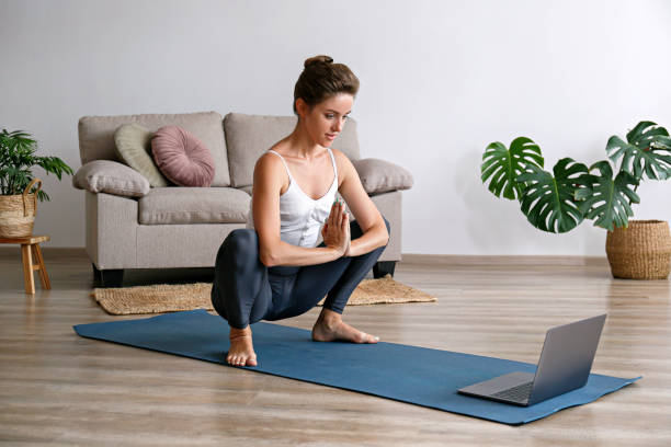 yogini trainiert zu hause - floor women sitting yoga stock-fotos und bilder