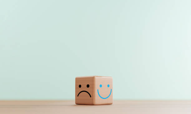 istock Smile face print screen on bright wooden cube block and sadness face on dark side for customer service evaluation and emotion mindset concept by 3d render. 1344575699