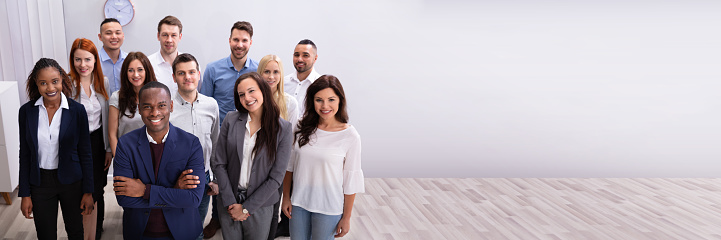 Modern, colorful business team looking at camera and smiling, ready to run for success