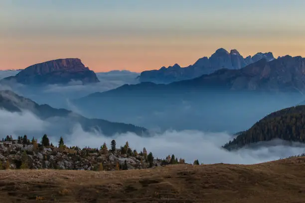 The valleys of Lake Valparola in the Italian Dolomites in the evening light with fog