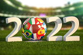 Football world championship 2022 in Qatar. Soccer ball with flags of world countries on the grass field of football stadium. .