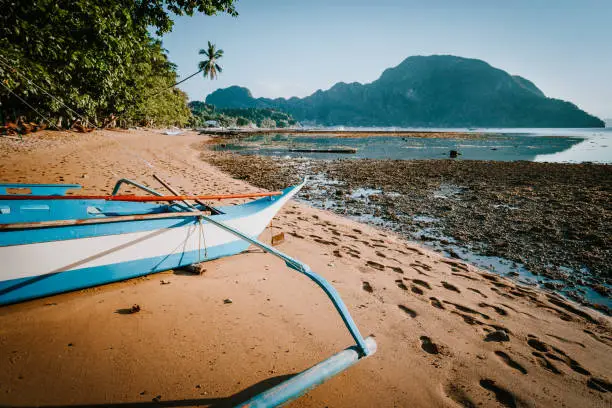 Photo of View of El Nido bay with local banca boat in front at low tide, picturesque scenery in the afternoon, Palawan, Philippines