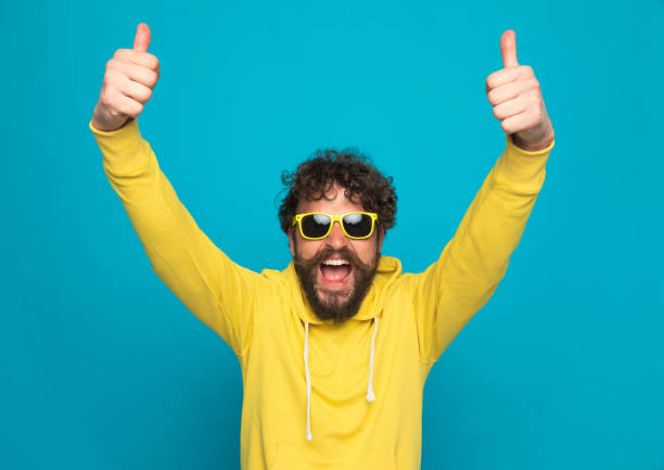 istock excited young casual man laughing and making thumbs up gesture 1344584897