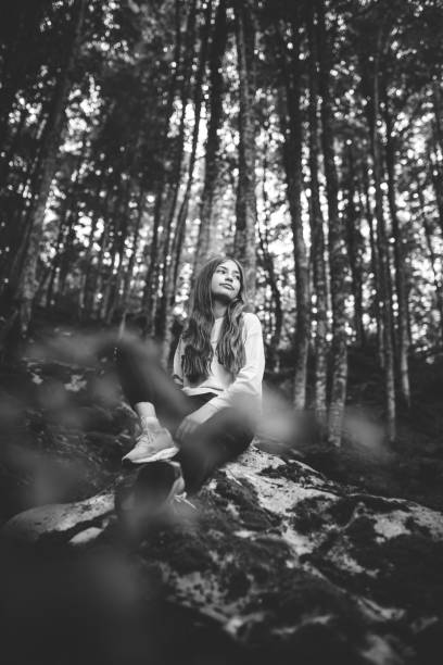 istock Teenager resting on rock while enjoying a hike in the green beech forest. 1344587876
