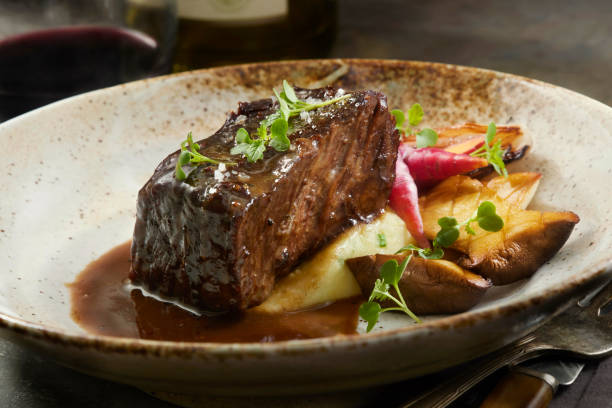 Red Wine Braised Boneless Short Rib with Black Truffle Au jus Red Wine Braised Boneless Short Rib  with King Oyster Mushrooms, Chive Mashed Potatoes and Black Truffle Au jus braised stock pictures, royalty-free photos & images