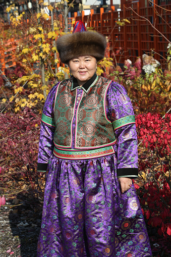 Woman in traditional national Buryat costume, Mongol dress. Beautiful girl from Buryatia. Ethnic fashion, autumn look. Folk style in clothes