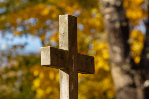 istock Grave stone cross in an old abandoned cemetery 1344594911