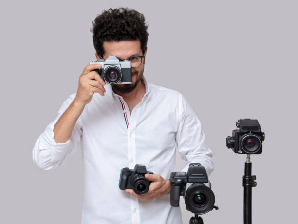 istock Professional photographer posing with his various cameras 1344595134