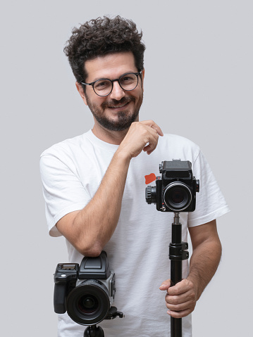 Professional photographer posing with his various cameras
