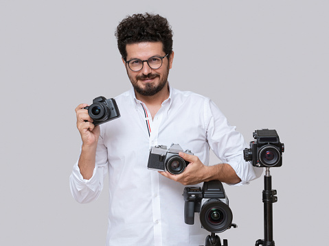 Professional photographer posing with his various cameras
