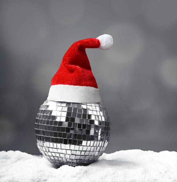 istock Beautiful mirrored Christmas ball with Santa hat on snow. 1344596490