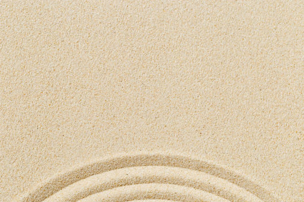 istock Lines drawing on sand, beautiful sandy texture. Spa background, concept for meditation and relaxation 1344598987