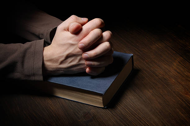 istock Hands folded in prayer over a Holy Bible 134460091