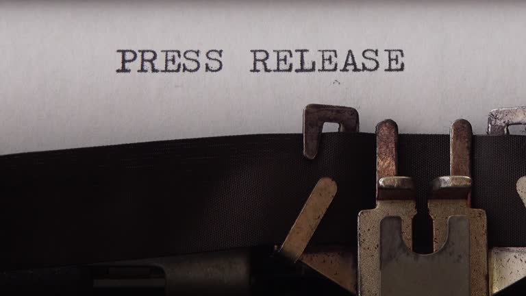 Typing phrase Press Release on retro typewriter. Close up.